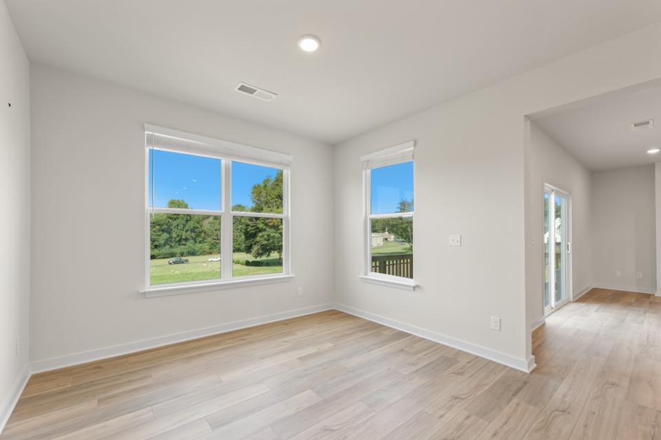 A room with windows and wood floors.
