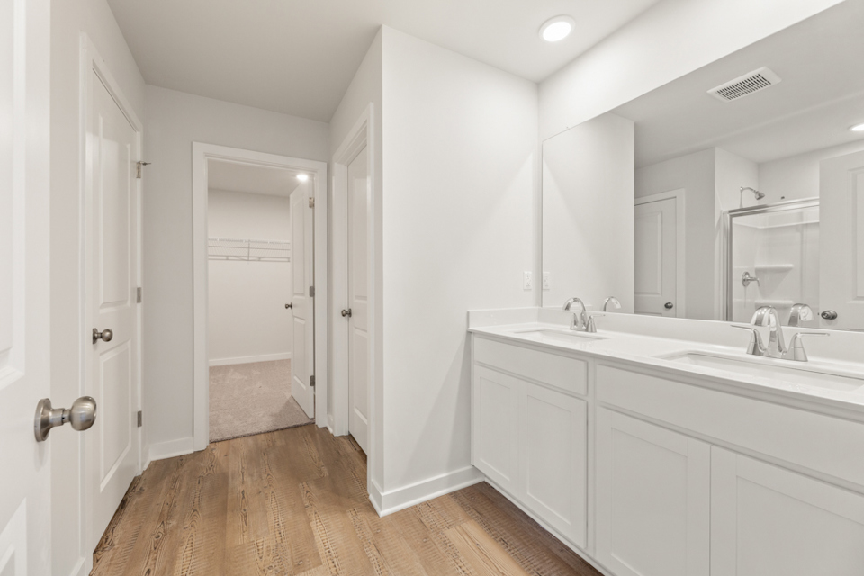 A bathroom with white cabinets.