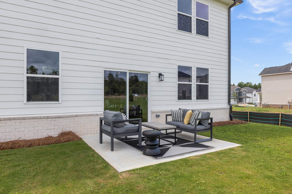 A house with a patio and a table and chairs in the front.