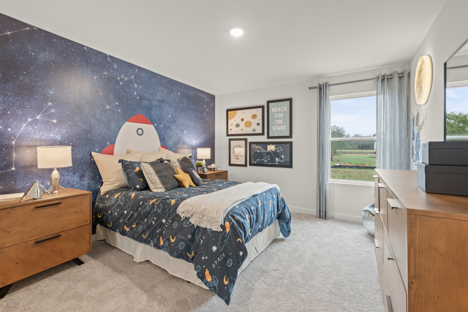 A bedroom with a bed and a cartoon character on the wall.