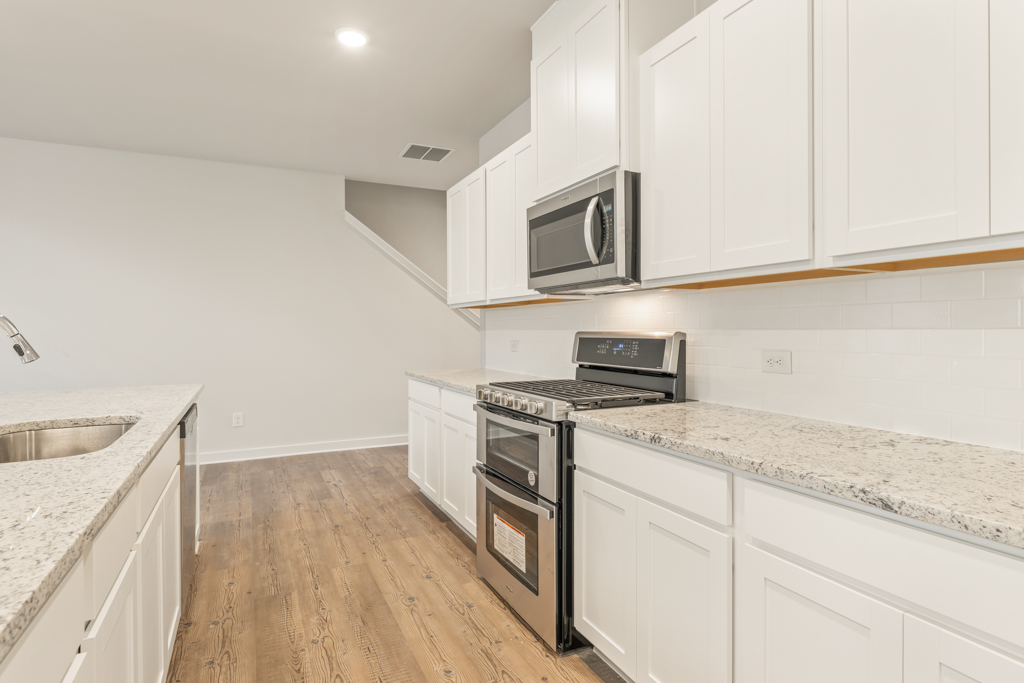 A kitchen with white cabinets.