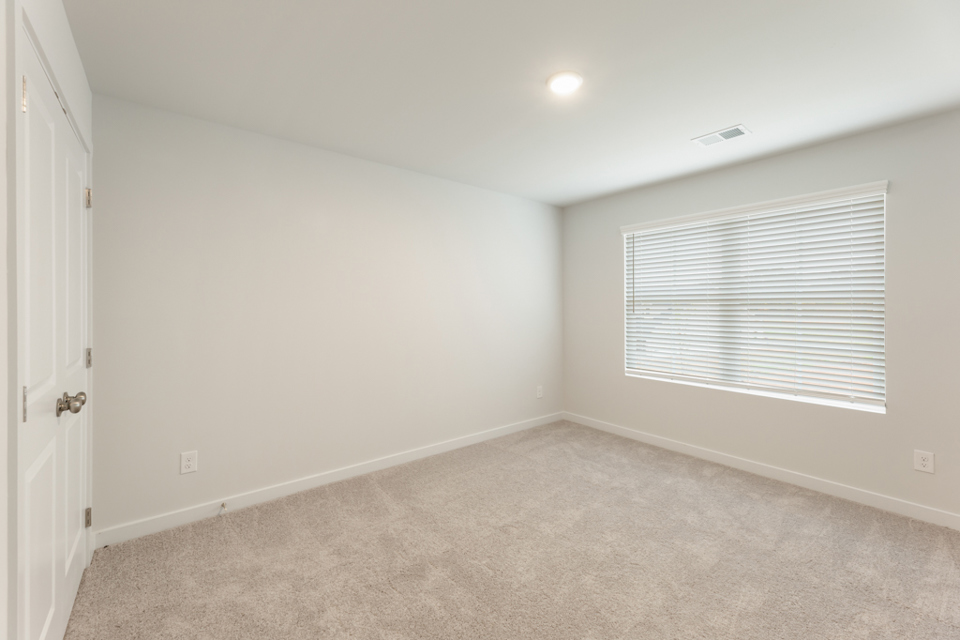 A room with a carpet and a window.