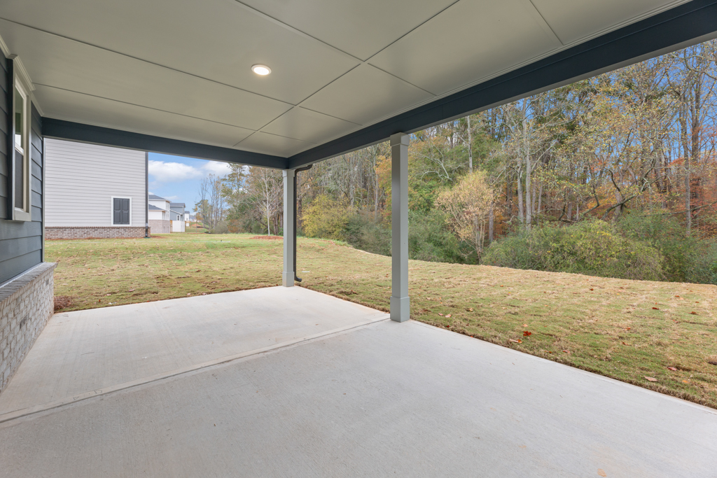 A covered walkway with trees and grass.