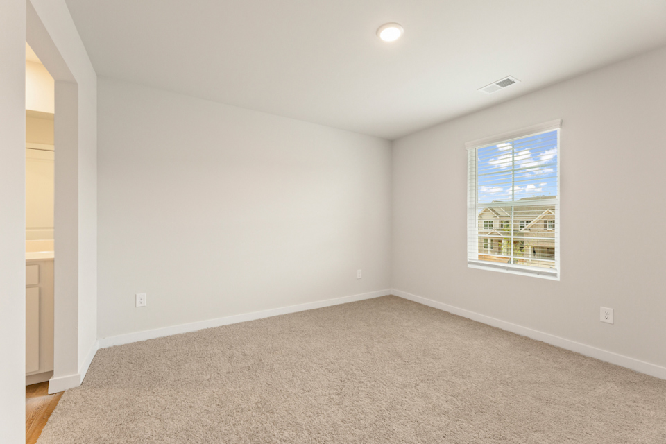 A room with a window and a carpet.
