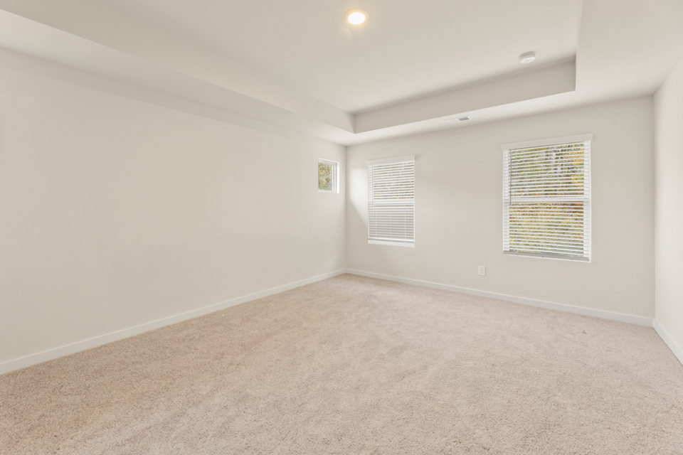 A room with a carpet and a window.