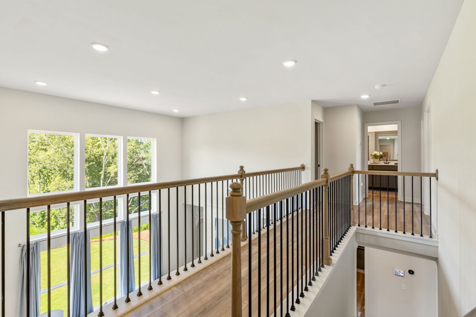 A room with a wood railing and windows.