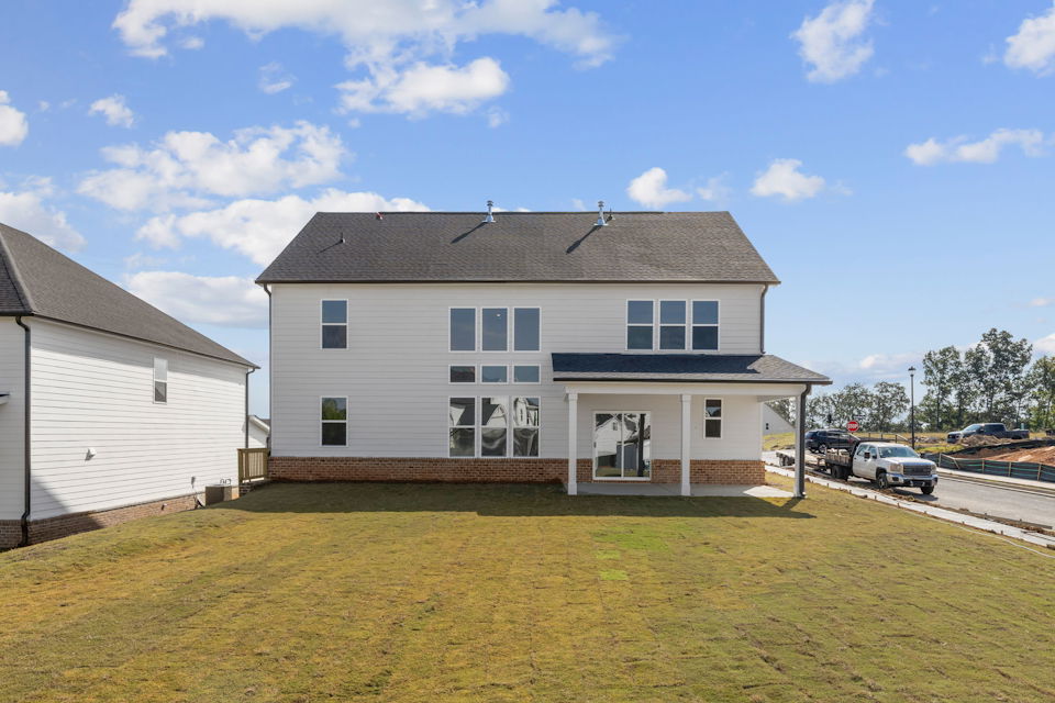 A white house with a parking lot.