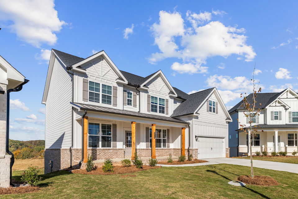 A white house with a green lawn.