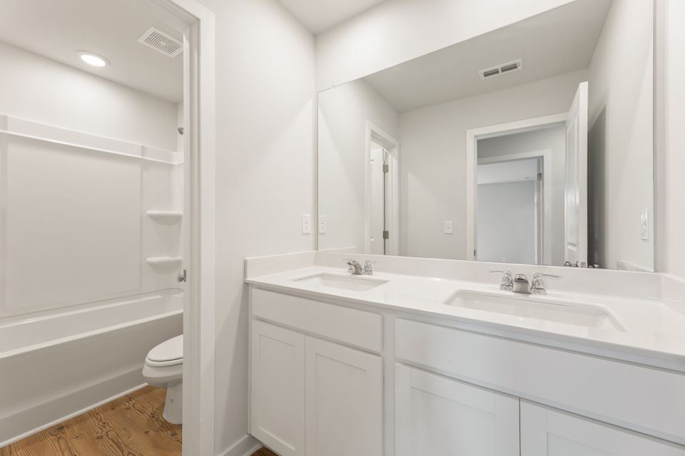 A bathroom with white cabinets.