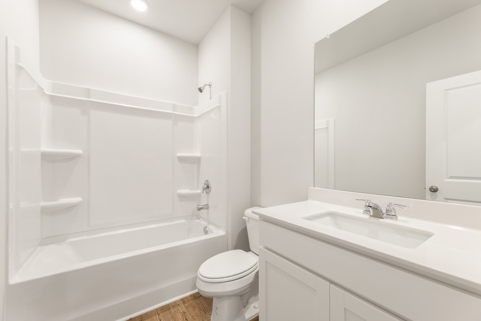 A bathroom with a tub sink and toilet.