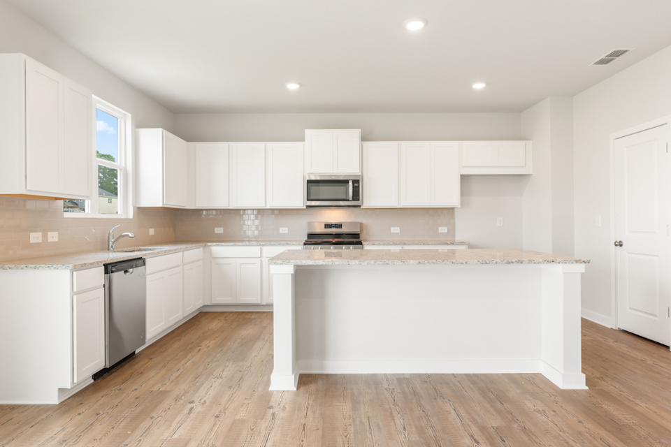 A kitchen with white cabinets.