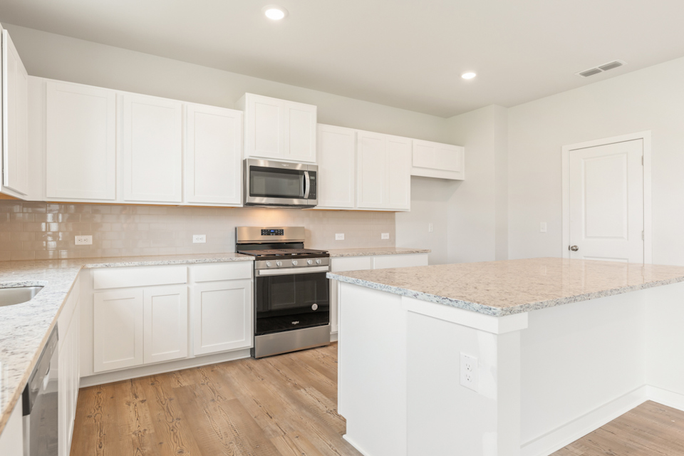A kitchen with white cabinets.