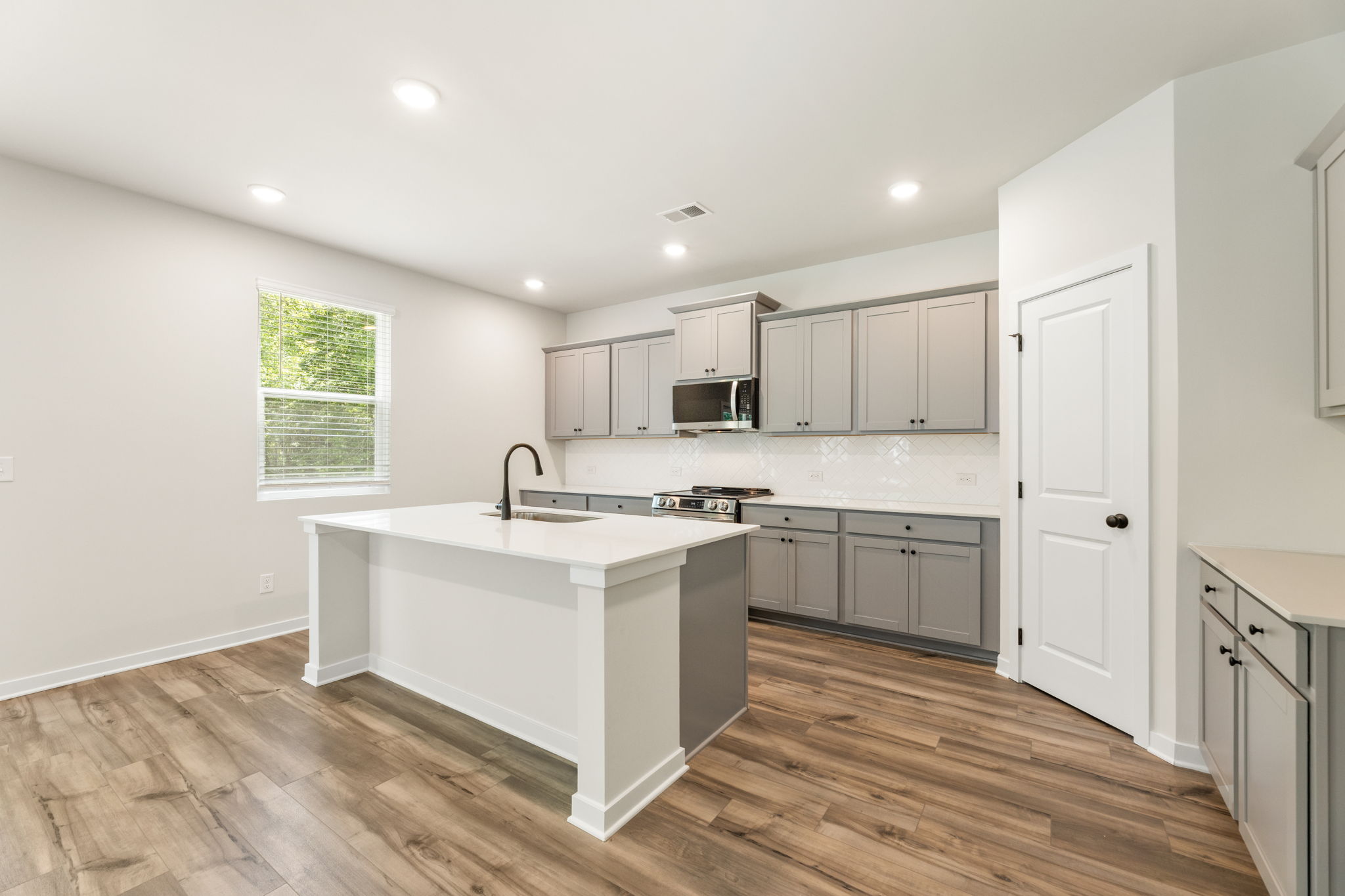 A kitchen with white cabinets.