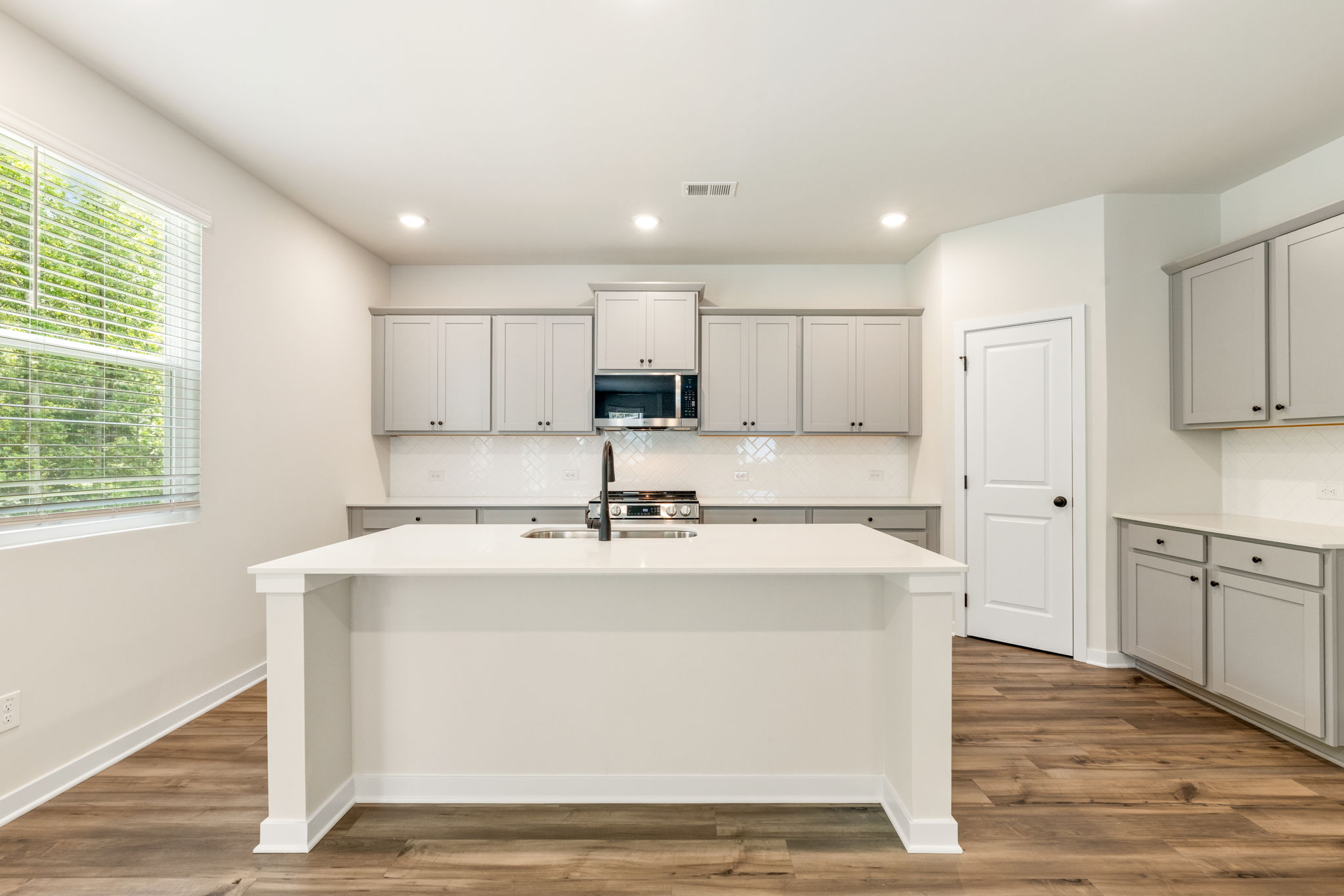 A kitchen with white cabinets.
