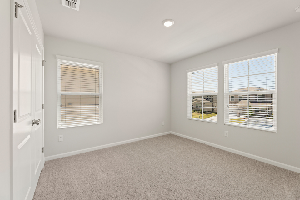 A room with a window and a carpet.