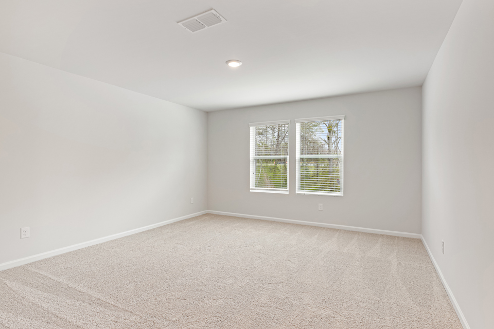 A room with a window and a carpet.