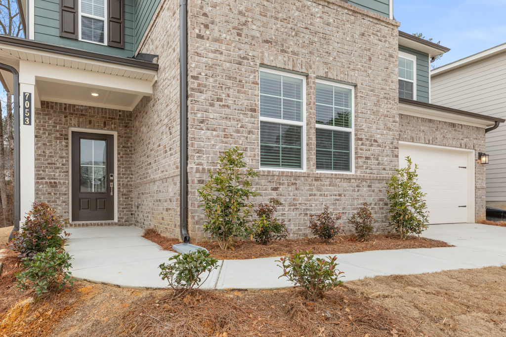 A building with a garage and plants.