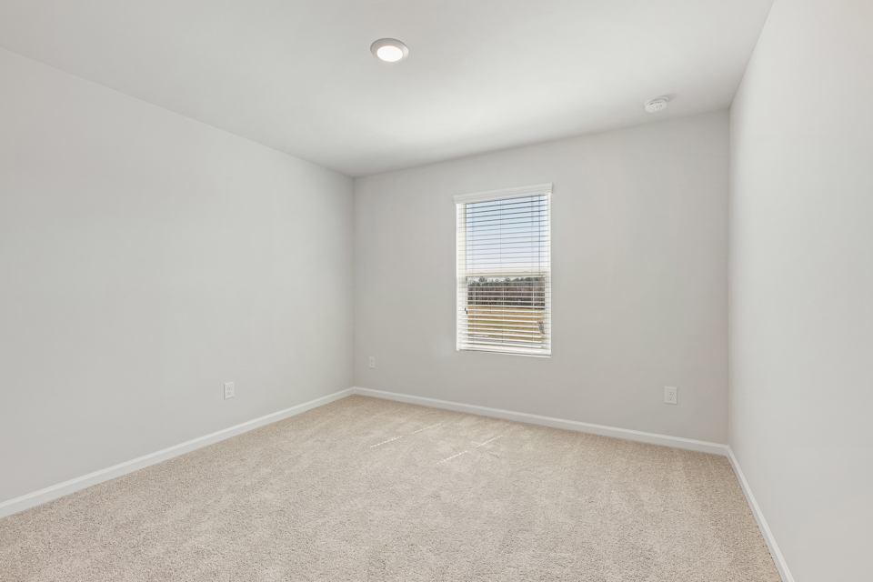 A room with a window and carpet.