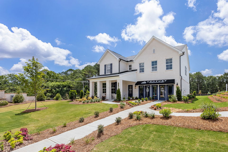 A large white house with a garden in front of it.