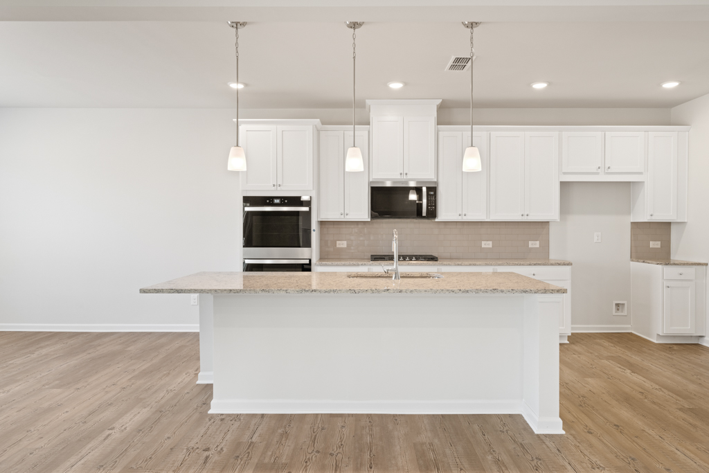 A kitchen with white cabinets.