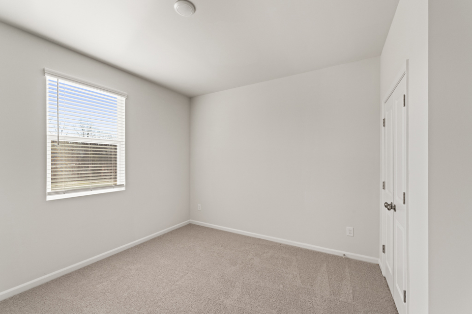 A room with white walls and a window.