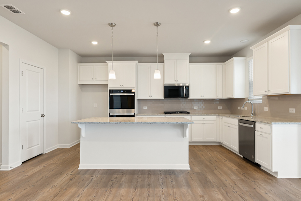 A kitchen with white cabinets.