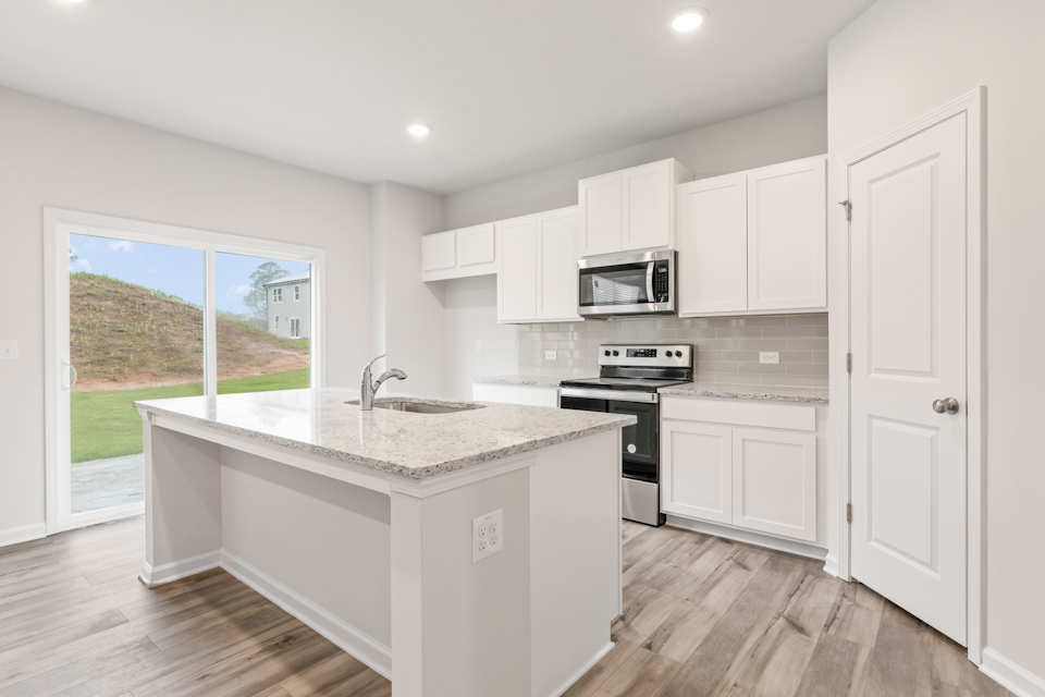 A kitchen with white cabinets.