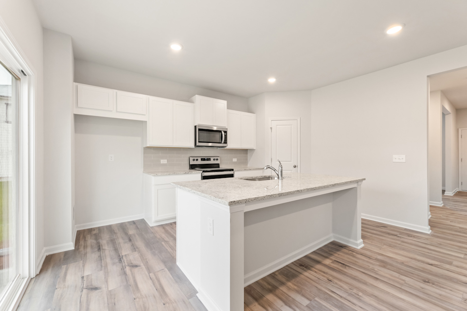 A kitchen with white cabinets.