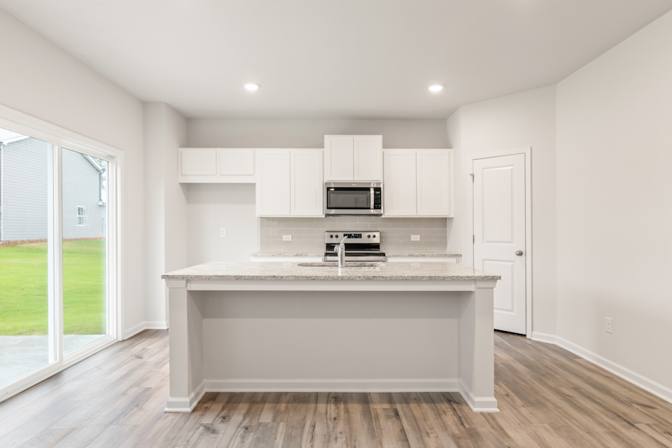 A kitchen with white cabinets.