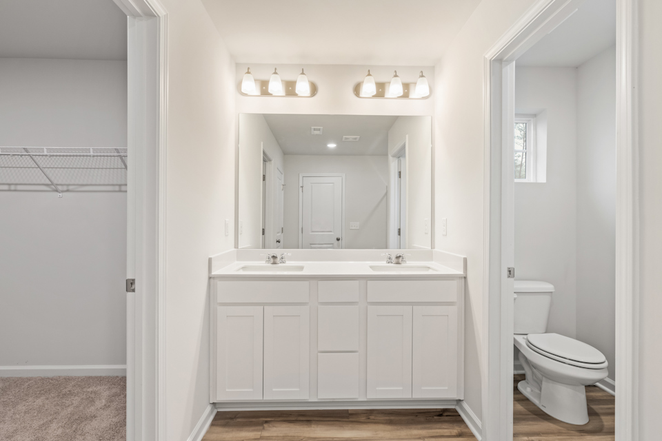 A bathroom with white cabinets.