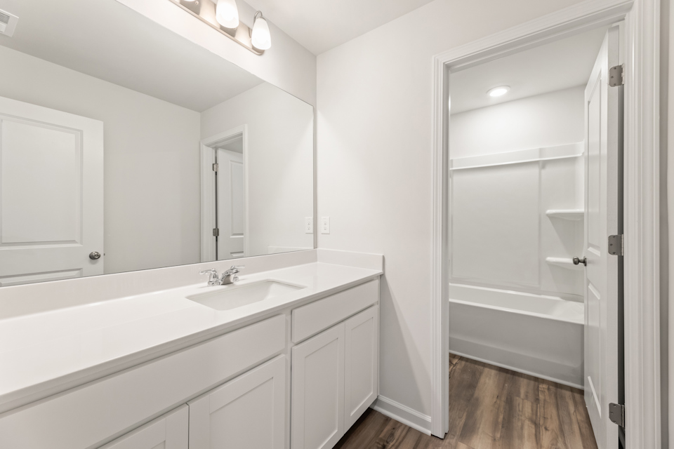 A bathroom with a sink and a shower unit.