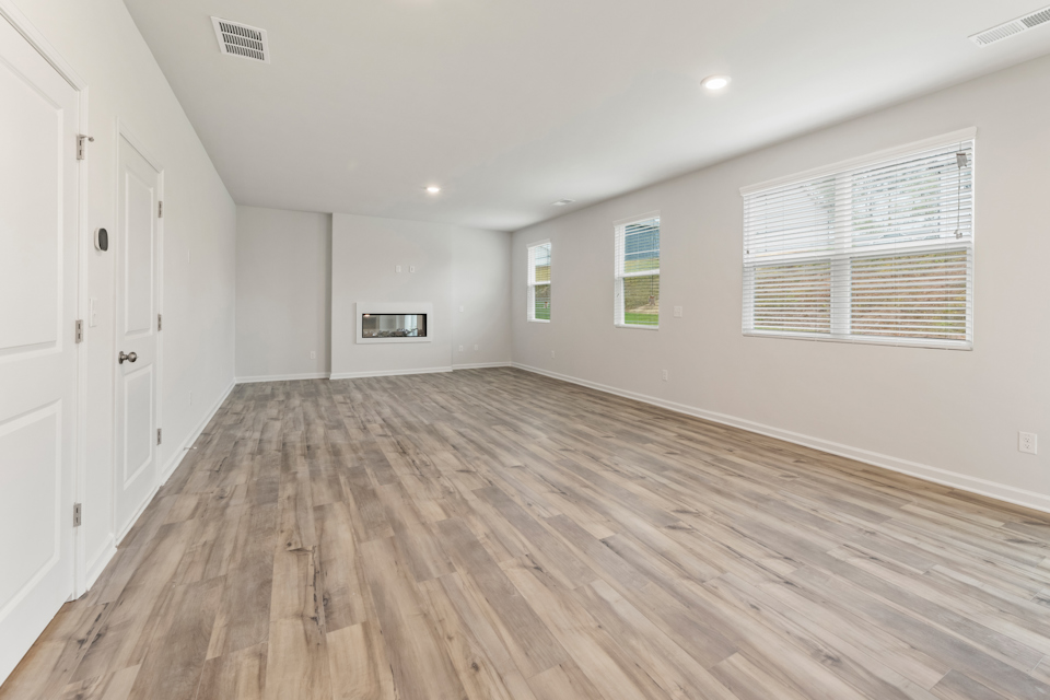 A room with white walls and wood floors.