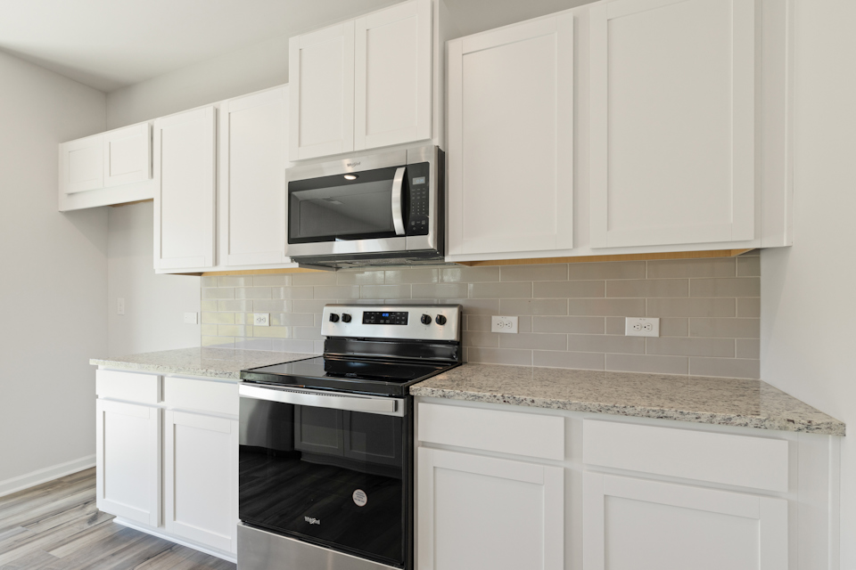 A kitchen with white cabinets.