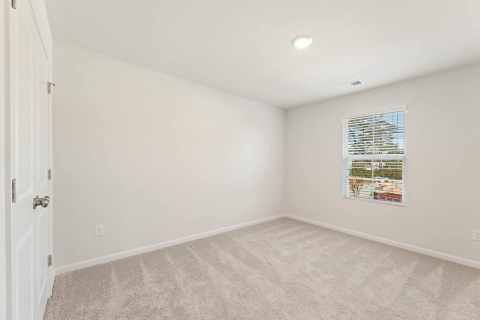 A room with a window and carpet.