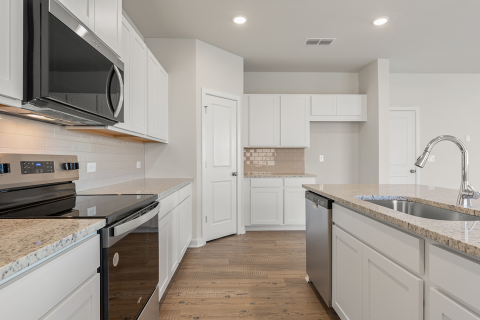 A kitchen with white cabinets.