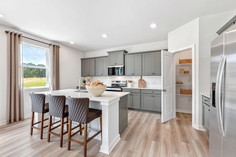 A kitchen with a dining table and a large window.