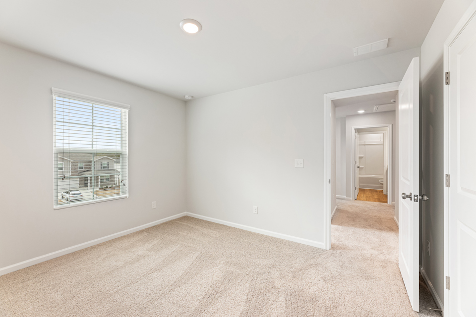 A room with a carpet and a door.