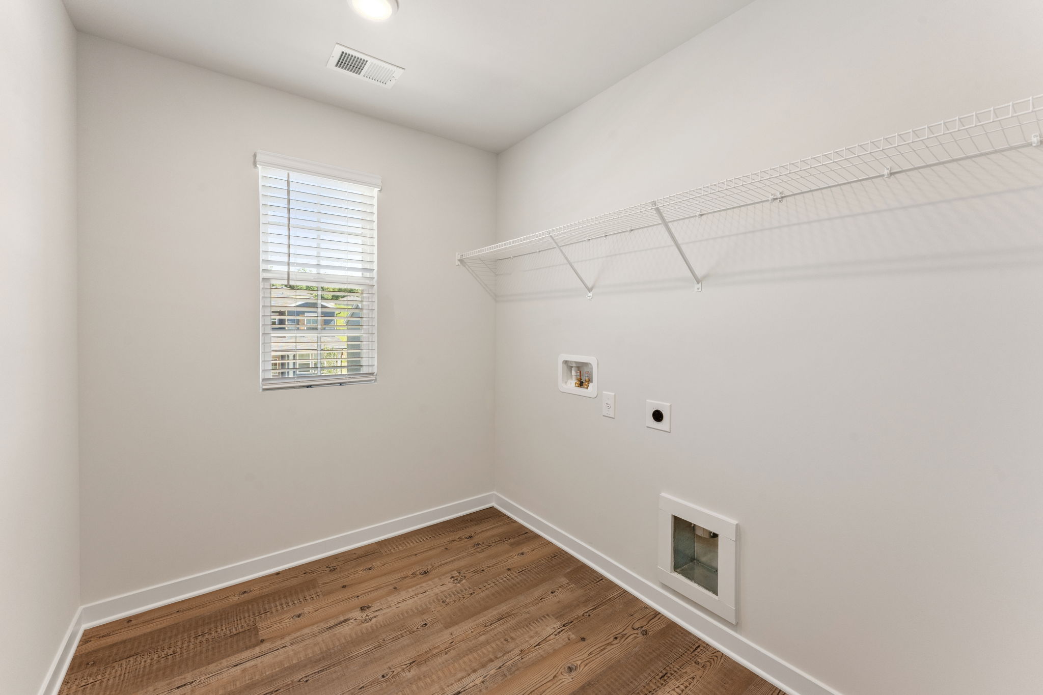 A room with a wood floor and a window.