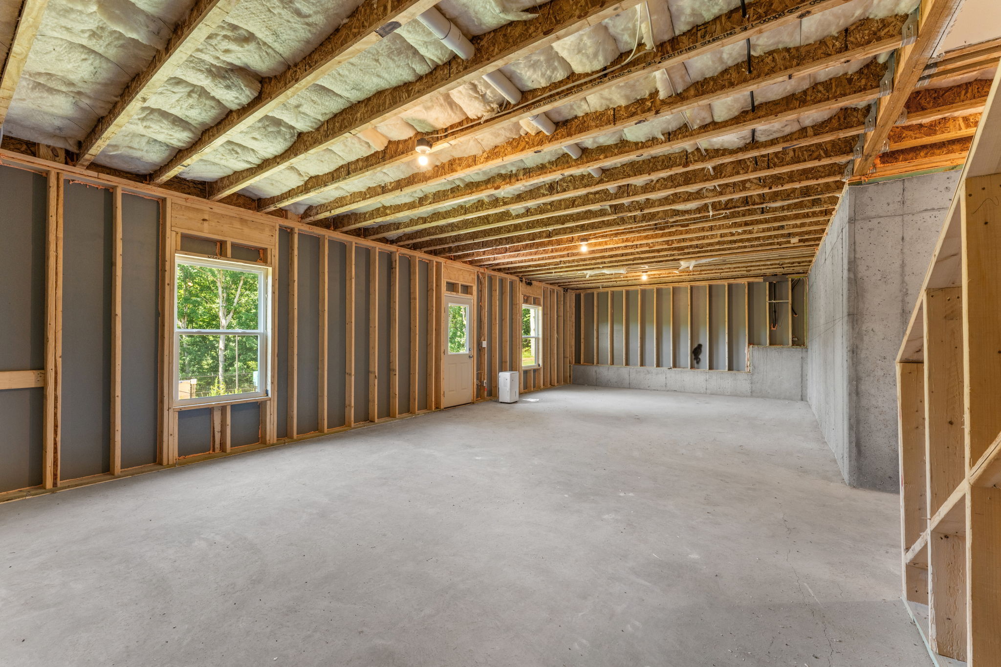 A room with a wood ceiling and windows.