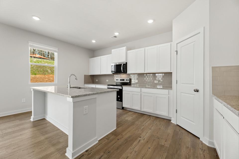 A kitchen with white cabinets.