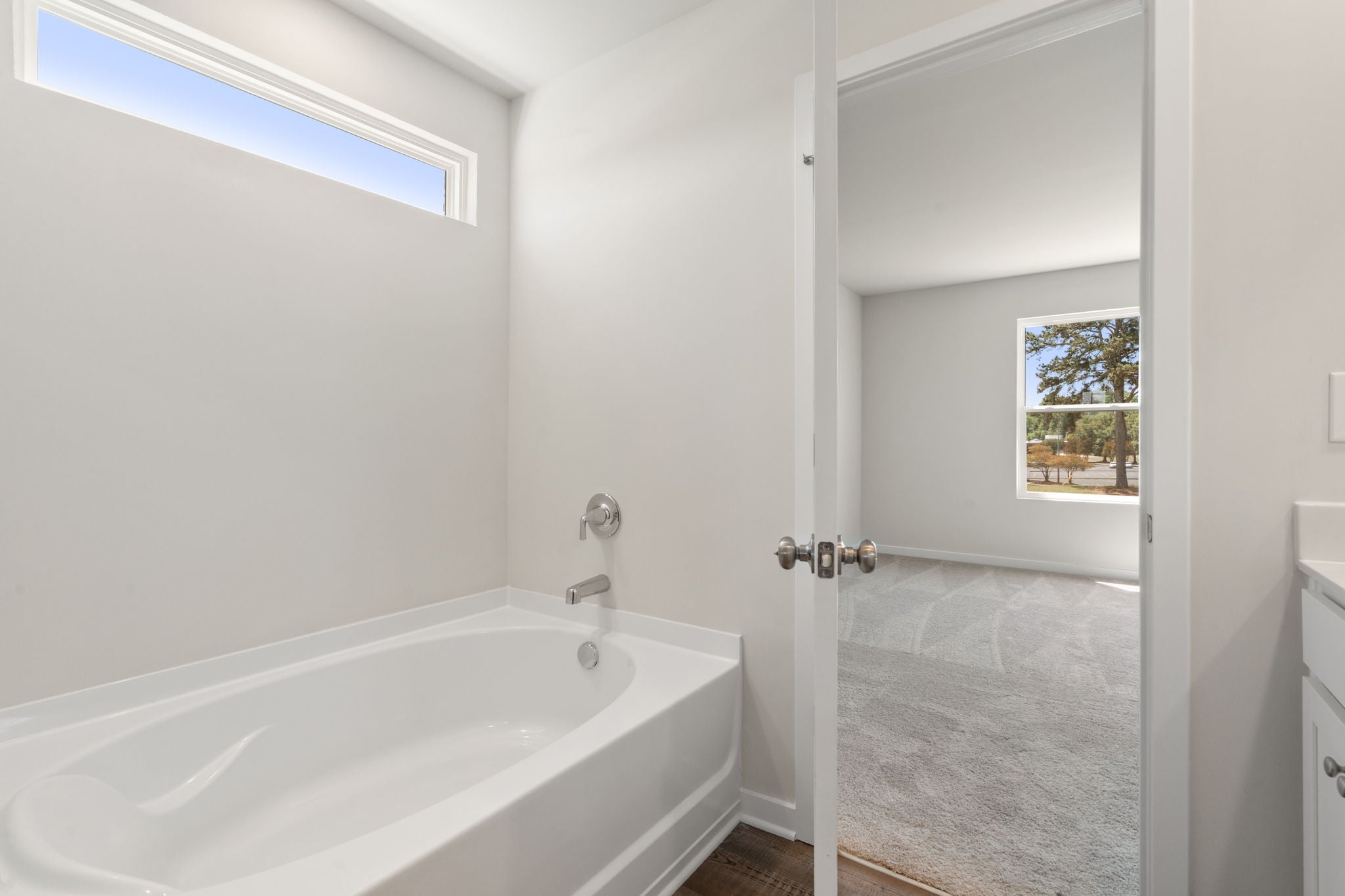 A bathroom with a tub and a window.