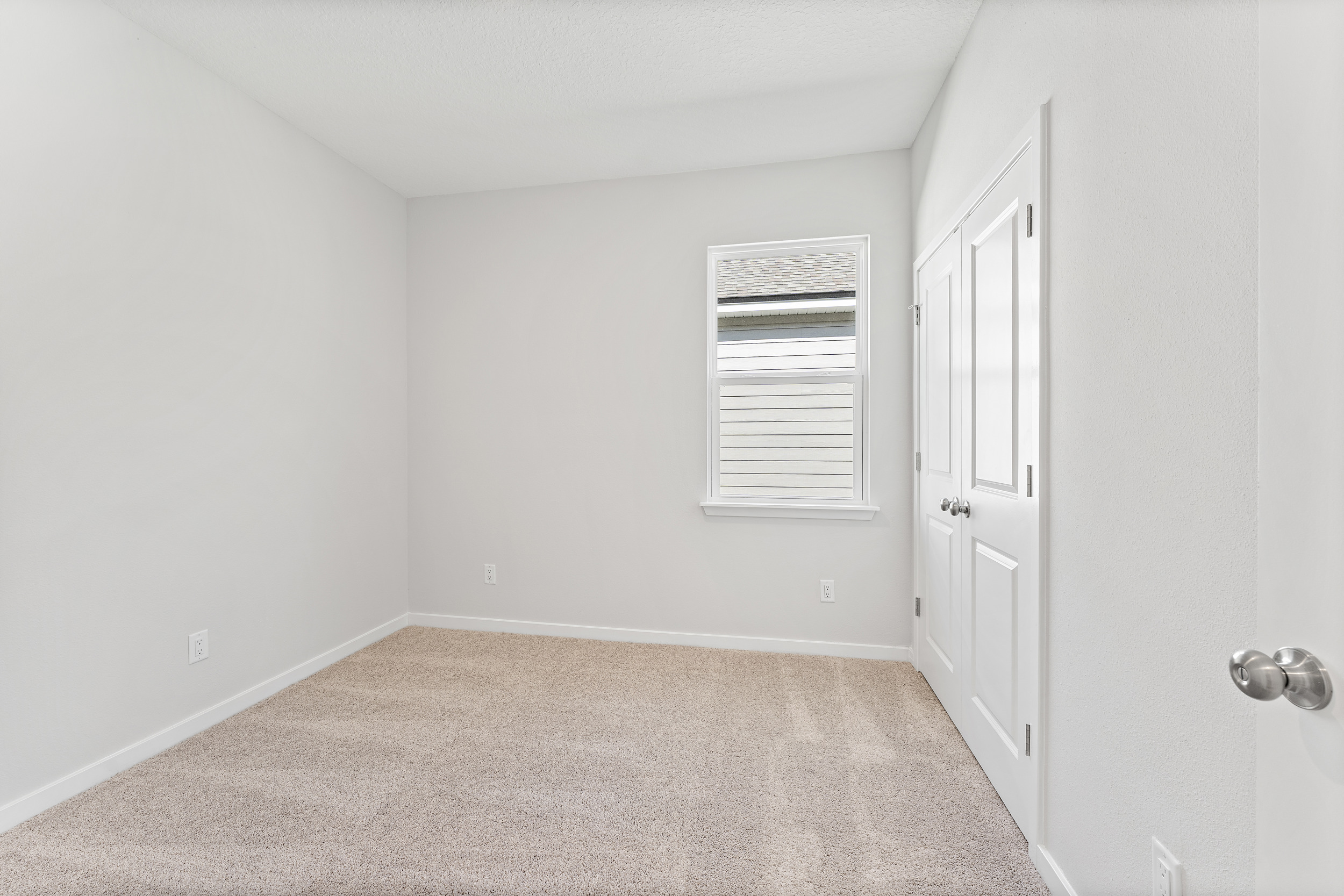 Lot 19 Cedar II Guest Bedroom with Window and Double Closet Doors at Camden Woods in Kingsland, GA