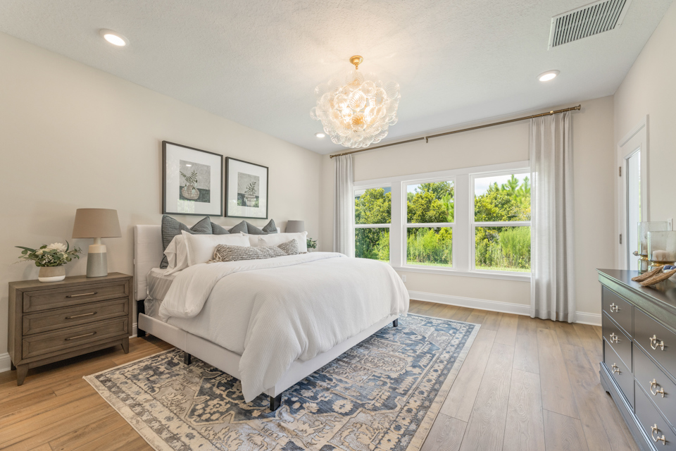 A bedroom with a bed and a chandelier.
