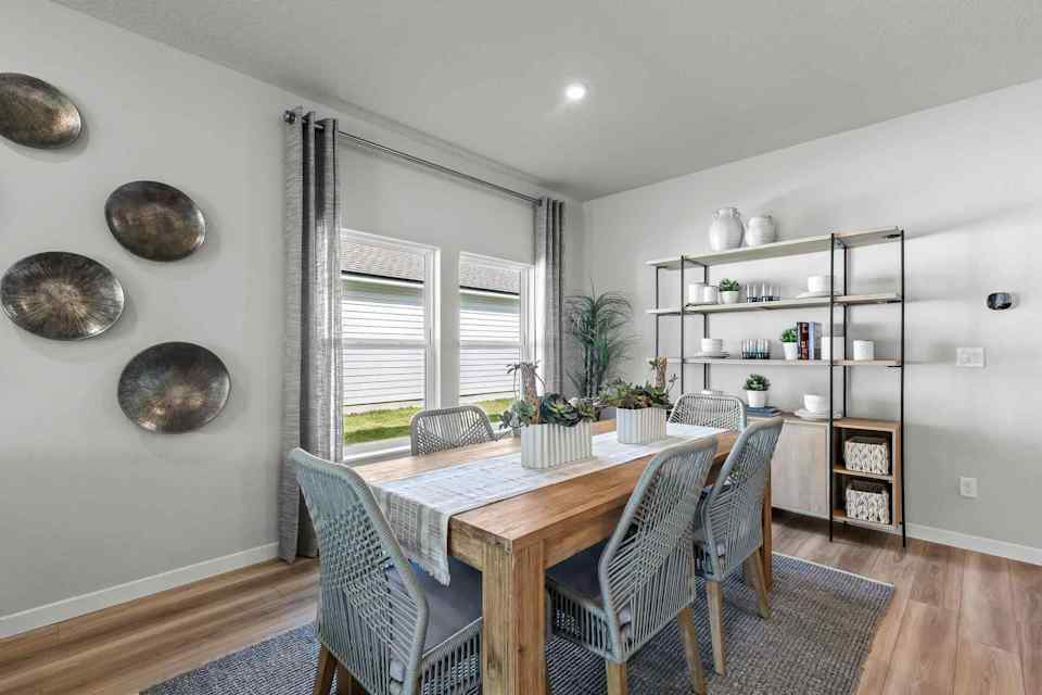 A dining room with a table and chairs.