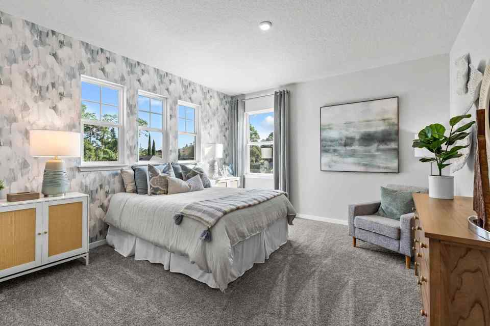 A bedroom with a bed and a chair.