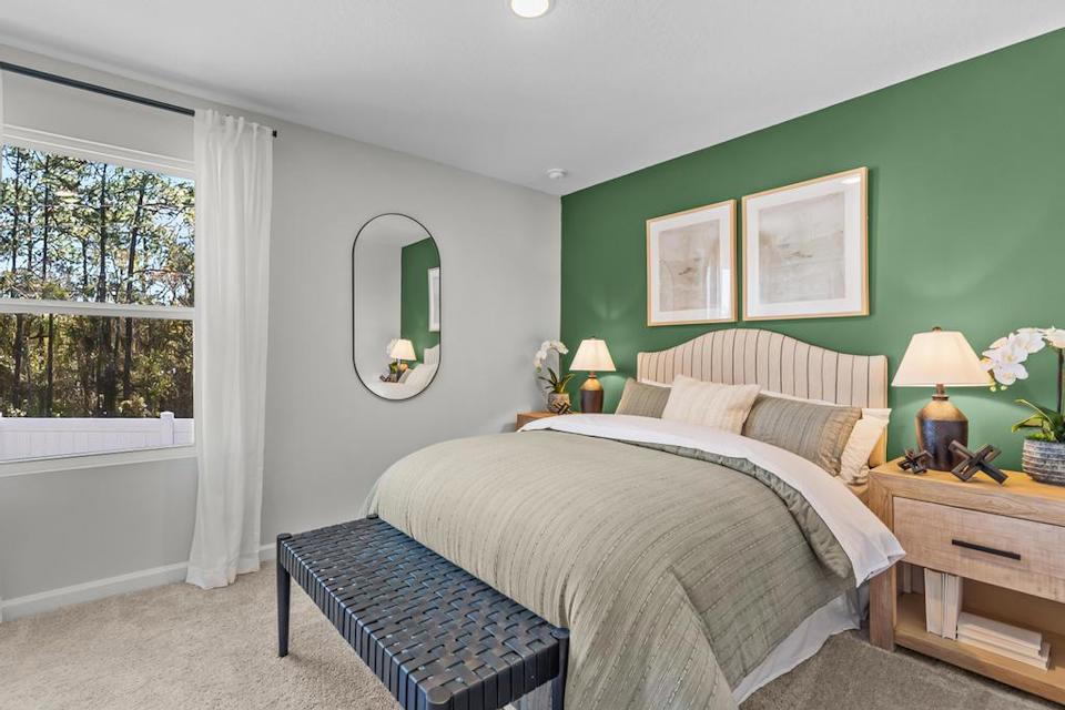 A bedroom with a bed and a mirror.