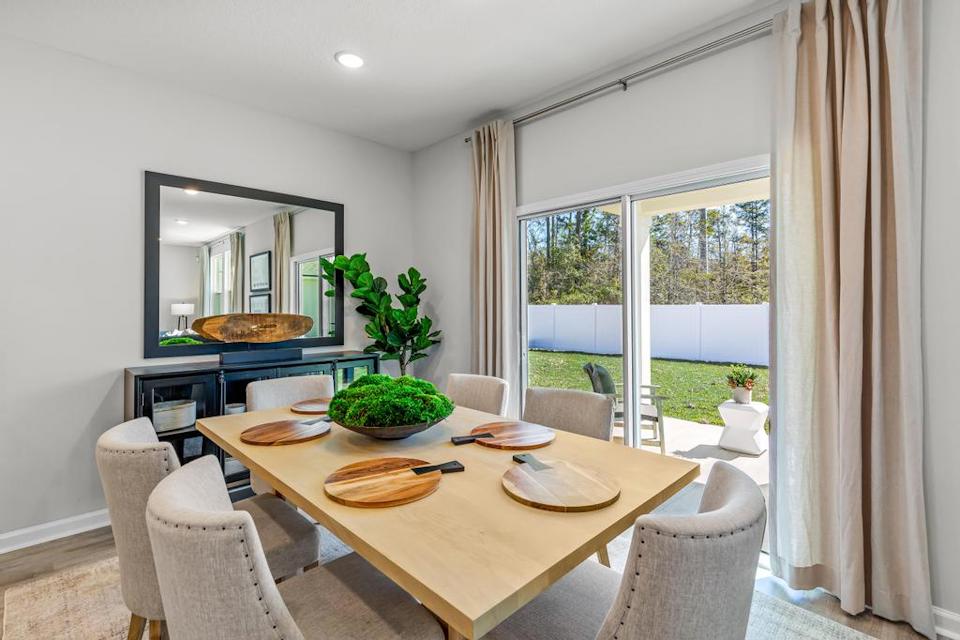 A dining room table with a large window.