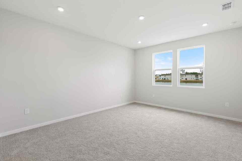 A room with a window and a wall with a painting on it.