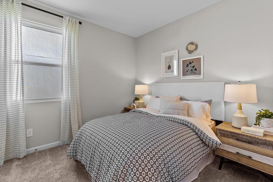 A bedroom with a bed and lamps.