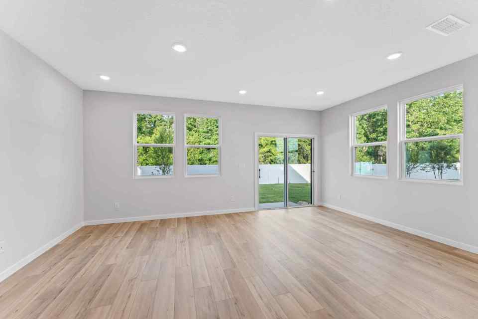 Davor Paired Home Empty Great Room with Windows at The Landings at Pecan Park in Jacksonville